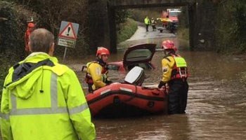 A boat in flood water covering a road